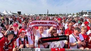 Fans des SC Freiburg warten auf die Ankunft der Mannschaft an der Messe