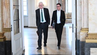 Winfried Kretschmann (l, Bündnis 90Die Grünen), Ministerpräsident von Baden-Württemberg, und Manuel Hagel, Landesvorsitzender der CDU Baden-Württemberg, gehen im Neuen Schloss in Stuttgart vor einem Bildungsgipfel gemeinsam durch eine Tür.