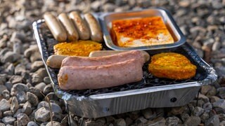 Drei jugendliche Mädchen grillen mit Einweggrill auf Autobahnbrücke und werfen Fleischreste auf A61 (Symbolbild).