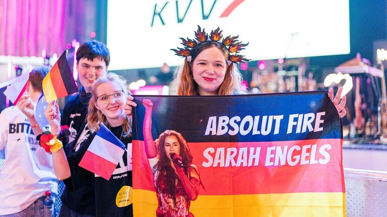 Eine Frau hält eine deutsche Fahne in der Hand und untersützt die deutsche ESC-Starterin Sarah Engels