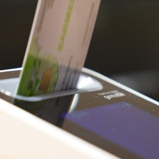 Ein Patient steckt seine Gesundheitskarte in ein Lesegerät.