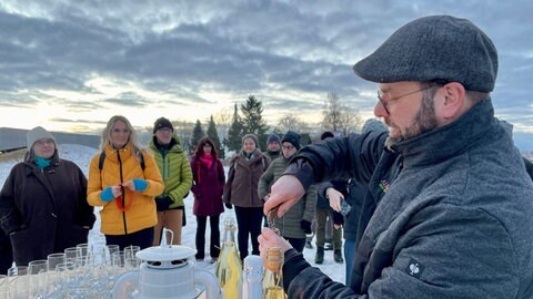 Winzer Jürgen Pfänder schenkt Wein von der Alb ein: Natur und Wissenswertes über die Kelten im Heidengraben bei Grabenstetten im Kreis Reutlingen. 