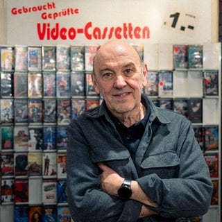 Mann steht in einer Videothek