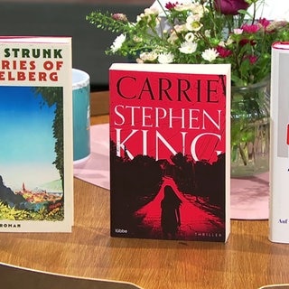 drei Bücher auf einem Tisch aufgestellt