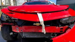 Demolierte Kühlerhaube eines roten Schrottautos: Ein Autohaus soll Betrug mit stark beschädigten Autos begangen haben.