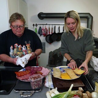 Michael Hummel und Susanne Nett bereiten in der Küche Raclette vor.