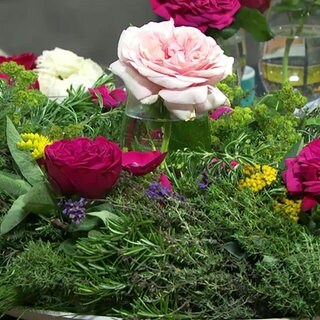 Kranz aus Kräutern mit Rosen eingesteckt