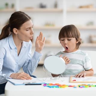 Kleiner Junge macht unter Anleitung einer Logopädin eine Sprechübung: Die Zahl der Kinder mit Sprachentwicklungsstörung steigt. Von Logopädie können aber auch Schlaganfall-Betroffene, Demenz-Erkrankte und sogar Säuglinge mit Fütterstörung profitieren.