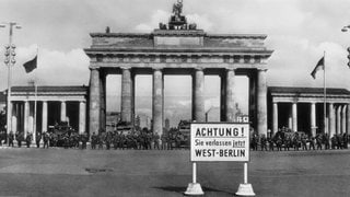Mauerbau am 13. August 1961: Einheiten der Nationalen Volksarmee, der Volkspolizei und der Betriebskampfgruppen riegeln die Sektorengrenze ab. Szene am Brandenburger Tor