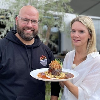 Mann und Frau halten Zwiebelrostbraten in die Kamera