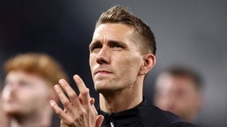 Nils Petersen schaut nachdenklich auf die Tribüne und klatscht. 