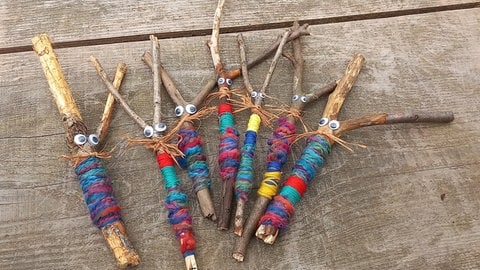 Die "Buntspechte" haben bunte Stockfiguren aus Ästen und Wolle gebastelt. 