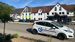 Auto der Lebenshilfe vor dem sanierten und neu eröffneten Lebenshilfehaus in Sinzig. Fast fünf Jahre nach der Flutkatastrophe im Ahrtal wird das Lebenshilfehaus in Sinzig jetzt offiziell neu eröffnet. 