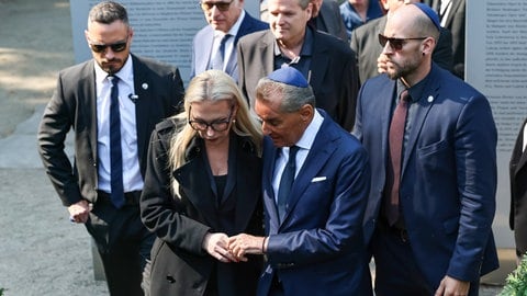 Katharina Wagner und Michel Friedman halten sich nach der Gedenkveranstaltung „Verstummte Stimmen“ an der gleichnamigen Ausstellung die Hand.