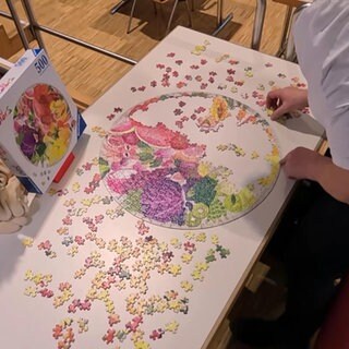 Eine Frau puzzelt an einem Tisch während einem Wettkampf