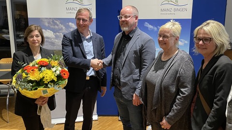Der zukünftige Landrat im Kreis Mainz-Bingen Thomas Barth von der CDU (zweiter von links) nimmt die Glückwünsche des Verlierers Steffen Wolf (SPD) entgegen.