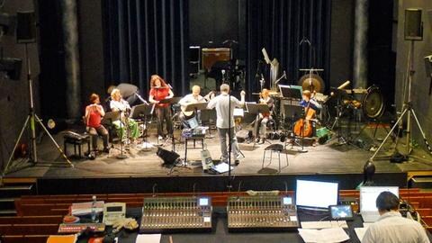 Sechs Musiker und ein Dirigent proben