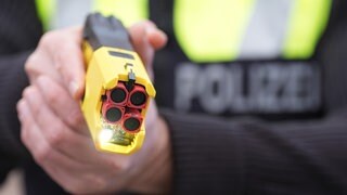 Ein Polizeibeamter hält einen Taser in den Händen. Die Gewerkschaft der Polizei (GdP) hat erneut den Einsatz der Elektroschock-Pistolen in Baden-Württemberg gefordert.