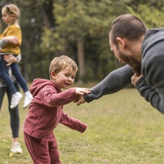Eltern und Kinder spielen zusammen draußen