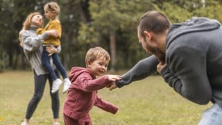 Eltern und Kinder spielen zusammen draußen
