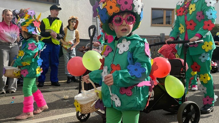 Als bunte Blumen verkleidete Kinder und Erwachsene beim Festumzug am Schwerdonnerstag 2025 in Mülheim-Kärlich.