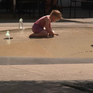 Kind spielt an Brunnen