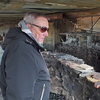 Gastronom Harald Sieder steht einem Monat nach dem Brand in den zerstörten Überresten seines "Restaurant" Seegugger in Rheinstetten.