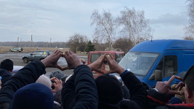 Bedürftige Ukrainer formen mit ihren Händen aus Dankbarkeit ein Herz.