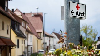 Ein Schild mit der Aufschrift «Arzt» hängt an einer Straßenlaterne. Im baden-württembergischen Landarzt-Programm ist fast jeder zehnte geschaffene Platz nicht mehr mit Studierenden aus dem Programm besetzt. 