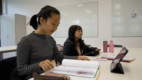 Zwei Frauen aus Myanmar sitzen in einer Schulbank. Sie machen in Mössingen eine Ausbildung zur Pflegekraft.