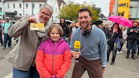 Bianca, Teasa und Moderator Corvin Tondera-Klein stehen zusammen und lachen in die Kamera.