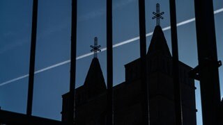 Symbolbild: Schatten der Vergangenheit. Siluette von zwei engstenden Kirchtürmen
