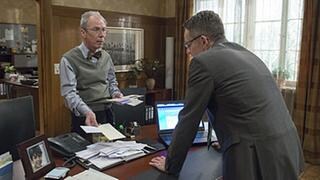 Herr Weiss und Bernhard im Bürgermeisterbüro, vor ihnen auf dem Schreibtisch ein großer Stapel Briefe