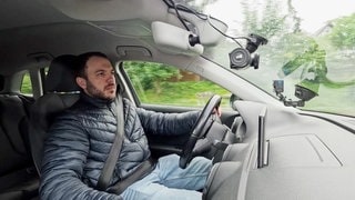 Ein Autofahrer mit einer Dashcam an der Windschutzscheibe. 