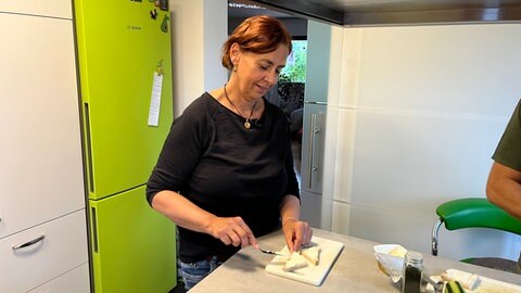 Jutta ist Butterbrot-Fan und streicht in ihrer Küche in Hechingen ein Brot. Am "Tag des deutschen Butterbrots" kommen einige Gäste