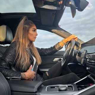 Fahrlehrerin Yasemin Yildiz sittzt am Steuer eines Autos