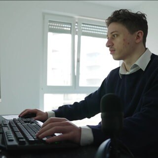 Ein junger Mann sitzt vor dem PC
