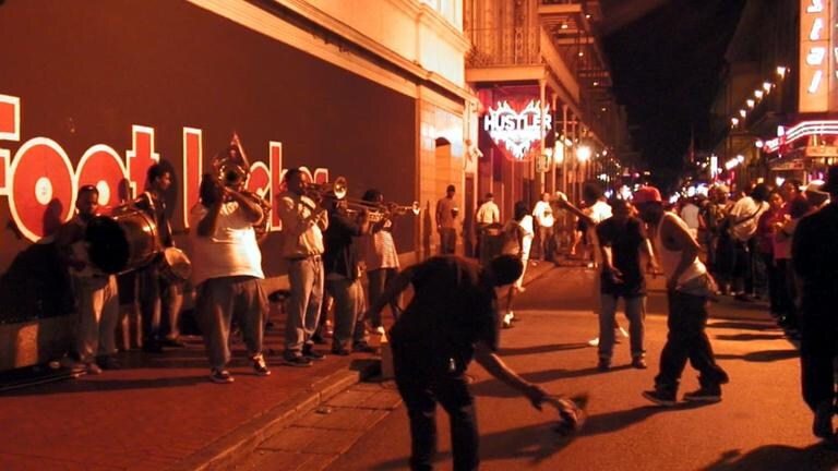 Im French Quarter der historischen Altstadt von New Orleans pulsiert das Leben. Touristen aus aller Welt bevölkern die Straßen, die eingerahmt sind von kleinen ein- oder zweistöckigen Häusern mit ihrer Architektur aus der französischen Kolonialzeit. Bourbon Street ist die Wiege des Jazz.