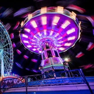 Das Kettenkarussell und Riesenrad auf dem Cannstatter Volksfest bei Nacht. Am 25. September startet das 179. Cannstatter Volksfest auf dem Wasengelände in Stuttgart.