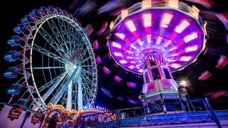 Das Kettenkarussell und Riesenrad auf dem Cannstatter Volksfest bei Nacht. Am 25. September startet das 179. Cannstatter Volksfest auf dem Wasengelände in Stuttgart.