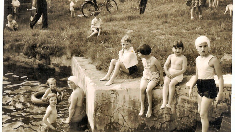 Besucherinnen und Besucher schwimmen im Freibad Lautenbach. Das Freibad steht im Rahmen des Zukunftspakets 2030 der Stadt Gernsbach auf der Kippe.