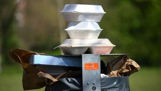 Leere Speise-Verpackungen stapeln sich in einem Park auf einem Mülleimer. Nachdem das Bundesverfassungsgericht in Karlsruhe die Verpackungssteuer in Tübingen gebilligt hat, wollen andere Städte nachziehen. 