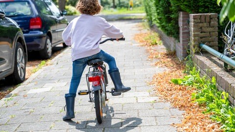 Ein Junge fährt auf seinem Fahrrad einen Weg entlang