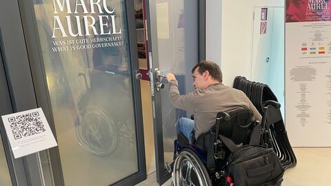 Diese Tür öffnet sich nicht automatisch. Menschen im Rollstuhl, die allein unterwegs sind, können sie ohne Hilfe gar nicht oder nur schwer öffnen.
