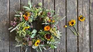Zum Schluss verschiedene Blüten, wie z.B. Ringelblume, Sonnenhut in den Kranz stecken.