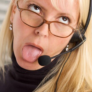 Blonde Frau spricht mit verdrehten Augen genervt in ein Headset: Unsere Gesellschaft misst dem Beruf viel Bedeutung bei: Identität, Anerkennung, Struktur. Was passiert, wenn wir arbeitslos werden oder einen Bullshit-Job als sinnlos empfinden?