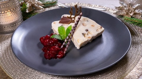Stollenparfait, das Dessert zum Weihnachtsmenü: Der Nachtisch ist auf einem Teller dekoriert und zum Servieren bereit.