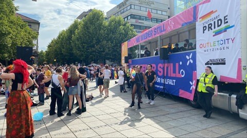 Menschen tanzen in der Nähe des Stuttgarter Karlsplatzes, bevor die Kundgebung zum CSD Stuttgart 2025 beginnt. 