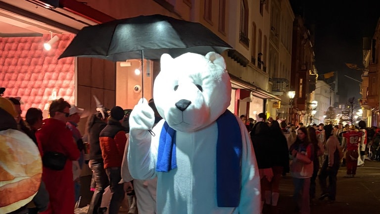 Karenval 2026: Beim Abendumzug in Boppard ist auch ein "Eisbär" mit Regenschirm mit dabei.
