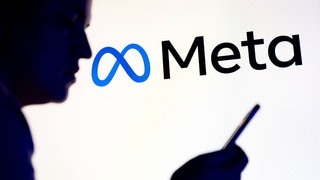 Mensch schaut auf Handy, im Hintergrund das Meta-Logo: Es gibt eine Sammelklage gegen Meta